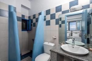 阿彻奇洛斯Agnanti Beach Apartments的一间带水槽、卫生间和镜子的浴室
