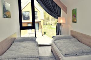 斯塔拉·里斯拉Chata3brezy Vysoké Tatry的一间卧室设有两张床和大窗户