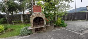 CięcinaAgroturystyka u Wiesi的围栏旁的院子内的砖砌壁炉
