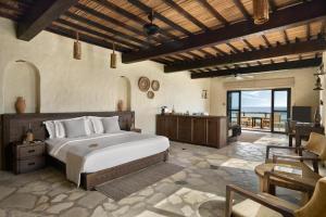 迪巴志加湾六感度假酒店的一间卧室配有一张大床和一张桌子