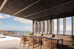 拉戈阿White Exclusive Suites & Villas的一个带桌椅的户外庭院和大海