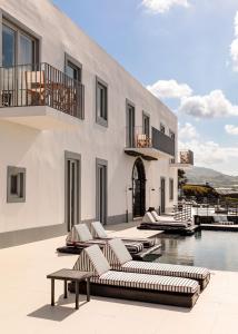 拉戈阿White Exclusive Suites & Villas的一座带游泳池和躺椅的度假村和一座建筑