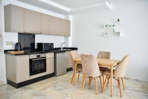 卡萨布兰卡Family Aparthotel的厨房配有木桌和椅子