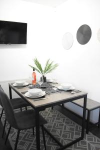 威森肖Maya Boutique Inn - Garden - Sleeps 6的餐桌、餐盘和椅子以及电视
