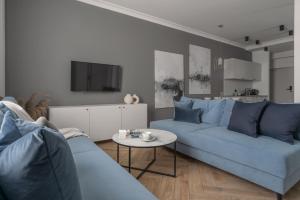 卡托维兹APARTIO ROOMS Katowice的客厅配有蓝色的沙发和桌子