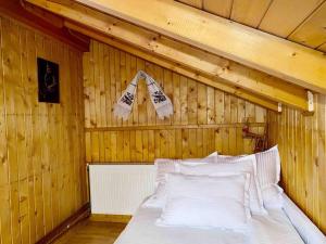 博尔沙Premium mountain view chalet的卧室配有木墙内的一张床