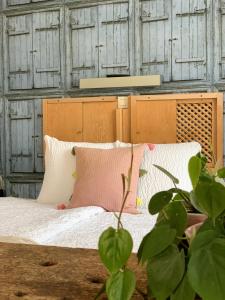 迪尔森-斯托科姆农德迪酒店的一张带白色粉色枕头和植物的床