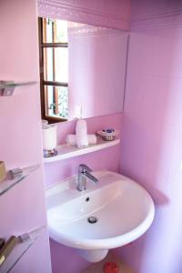 Áno KorakiánaThe Little House Corfu的粉红色浴室内的白色水槽,设有窗户