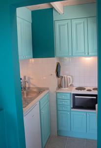 Áno KorakiánaThe Little House Corfu的厨房配有蓝色橱柜和水槽