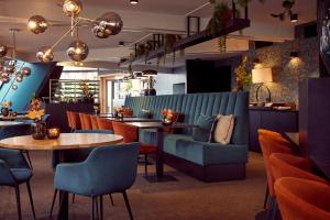 德拉赫滕凡德瓦克酒店的餐厅设有蓝色的沙发和桌椅