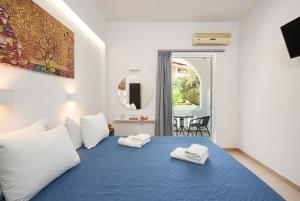 普拉基亚斯Afroditi Hotel的一间卧室配有蓝色的床和2条毛巾