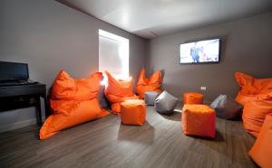 泰恩河畔纽卡斯尔司丽普背包客旅馆的客房设有橙色椅子和平面电视。