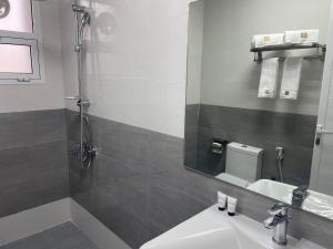 杜科姆Season Inn Hotel Apartment_Duqm的一间带水槽、淋浴和镜子的浴室