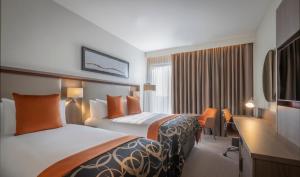 曼彻斯特Clayton Hotel Manchester City Centre的酒店客房配有两张床和一张书桌