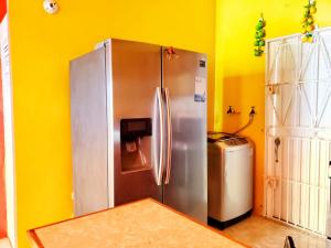 The RockSensational 2 Bedroom Getaway in Florence Hall的厨房设有黄色墙壁上的不锈钢冰箱