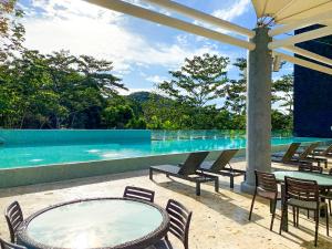ParaísoSummit Rainforest Golf Resort & All Inclusive的一个带桌椅的庭院和一个游泳池