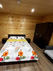 康斯坦察Magic Box的一间卧室配有一张带花卉床罩的床