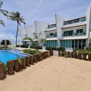 保利斯塔Maria Farinha Residence Prince - LocarHouse的海滩上的一座建筑,设有游泳池