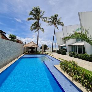 保利斯塔Maria Farinha Residence Prince - LocarHouse的棕榈树建筑旁边的游泳池