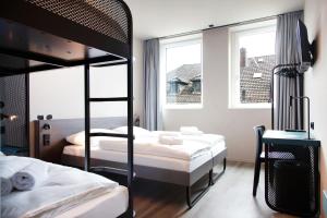 不莱梅MEININGER Hotel Bremen Hauptbahnhof的一间卧室设有两张双层床和一扇窗户。