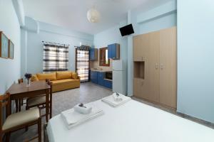 ÓrmosSpertos Apartments的厨房以及带床和桌子的客厅。