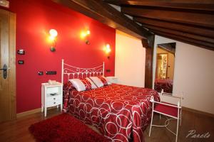Miengo维多利亚旅馆的红色的卧室,配有一张床和红色的墙壁