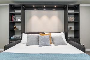 阿罕布拉Omeo Suites的卧室配有带枕头的大型白色床