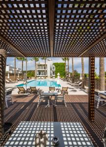 加藤-达拉特索Sea View Hotel & Apartments的一个带游泳池和桌椅的庭院