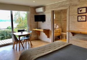 潘吉普伊Amukan Lodge的一间卧室配有一张床、一张桌子和一张桌子