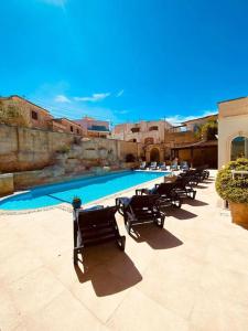 纳克萨Velver Mansion, Malta - Luxury Villa with Pool的游泳池旁的一排椅子