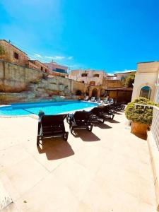 纳克萨Velver Mansion, Malta - Luxury Villa with Pool的游泳池旁的一排椅子