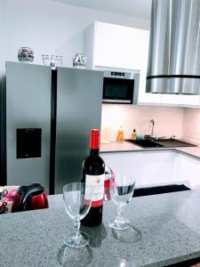 巴黎EIFFEL TOWER PENTHOUSE的厨房柜台上的一瓶葡萄酒和两杯酒杯