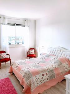 巴黎EIFFEL TOWER PENTHOUSE的一间卧室配有一张床和两张红色椅子
