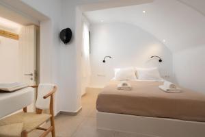 阿吉奥斯普罗科皮奥斯Melidron Hotel & Suites的一间卧室配有一张床、一张桌子和一把椅子