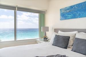 坎昆Ocean View Three Bedroom, Three Story Penthouse by the Beach的一间卧室设有一张床和一个海景大窗户