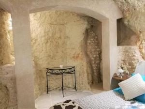 LunayCave du Coteau 2的卧室配有一张石墙床