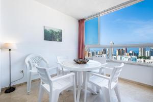 贝尼多姆Gemelos 22 Resort Apartment 3-18-B Levante Beach的窗户客房内的白色桌椅