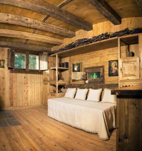 圣贾科莫Chalet Euthalia Restaurant & Suites的卧室配有一张床铺,位于带木墙的房间内