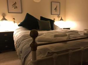 MattishallLavender Cottage的一间卧室配有一张带两个灯的床