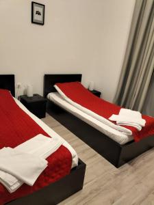 马里瑟尔Pensiunea CASA SPANDO的一间卧室配有两张红色和白色床单