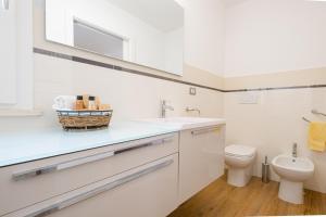 莱乌卡Chiara & Giulia Apartments by HDSalento的白色的浴室设有卫生间和水槽。