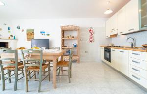 莱乌卡Chiara & Giulia Apartments by HDSalento的厨房配有桌椅和水槽。