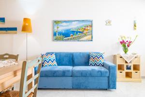 莱乌卡Chiara & Giulia Apartments by HDSalento的客厅里一张蓝色的沙发,墙上挂着一幅画