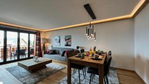 威拉尔-苏-罗伦Zenith Views by Villars Luxury的客厅配有桌子和沙发