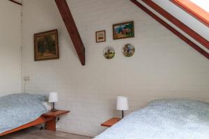 哈弗尔特Het Grote Paard的卧室配有两张床,墙上挂有图片