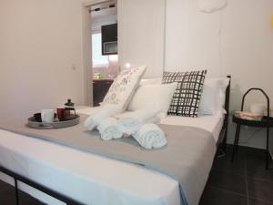 雅典My Sweet Home BnB North的一张带白色枕头的床和毛巾托盘