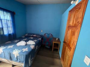 兰金Casa " MARY "的一间卧室拥有蓝色的墙壁和一张床,设有木门