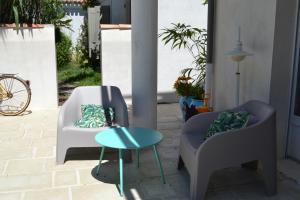 奥雷龙圣皮耶尔亚特兰提克酒店的庭院里设有两把椅子和一张桌子