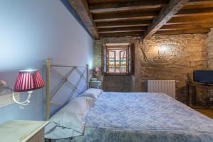 圣地亚哥－德孔波斯特拉Asador de Roxos Casa Albardonedo的一间卧室配有一张带蓝色棉被的床