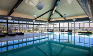 金德拜恩地平线雪山莱吉斯酒店的一座大型游泳池,位于一座带窗户的建筑内